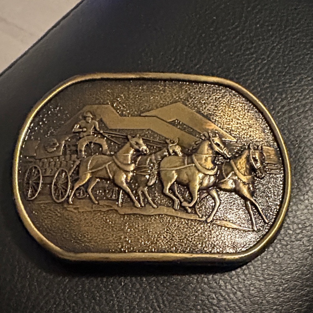 Bronze belt buckle featuring chuck wagon team